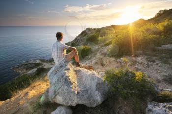  Man sitting on the rock in mountain and for watching sunrise.