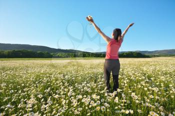Happy girl in daisy wheel spring flower field. Emotional and nature scene. 