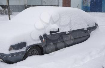 Car under snowdrift. Winter problem scene.