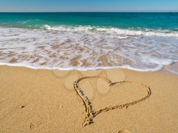 Heart on the sand of a beach. Romantic composition.