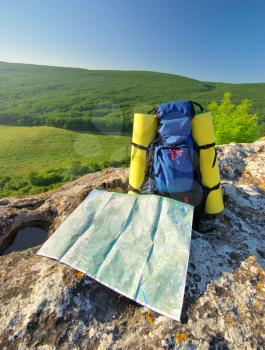 Backpack and map in mountain. Element of design.