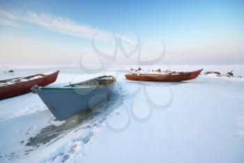 Boat on ice. Winter landscape composition.