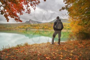 Man standing alone on the pond. Conceptual nature and people scene. Autumn spring tume.