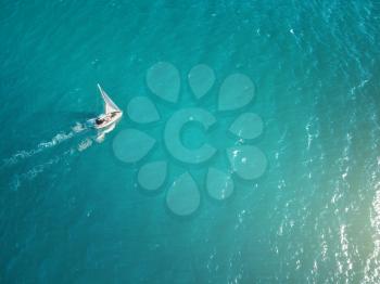 Aerial view of yacht in sea. Beautiful summer seascape with ships, clear azure water at sunny day. Top view.