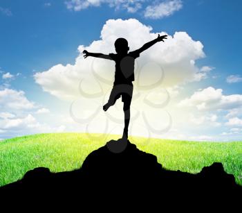 Happy silhouette of boy enjoy the nature. Spread arms to the sun and deep sky. Emotional and coceptual scene.
