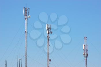 Telecommunication radio antenna towers. Technology construction on sky background.
