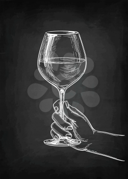 Hand holding a glass of wine. Chalk sketch on blackboard background. Hand drawn vector illustration. Retro style.