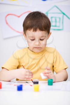 Portrait of a cute boy showing her hands painted in bright colors