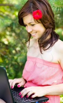 Young woman is playing on laptop, outdoor shoot