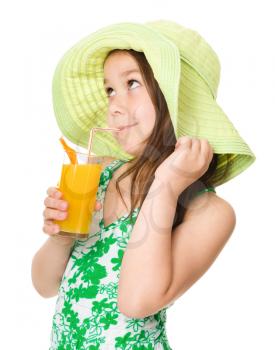 Cute girl is drinking orange juice using straw, isolated over white