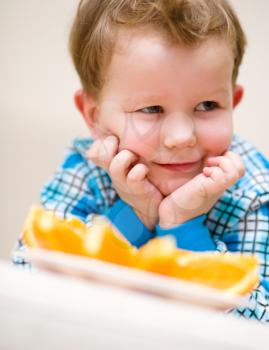 Portrait of a happy little boy with orange