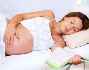 Sleeping pregnant woman on bed