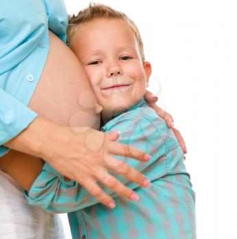 Happy child holding belly of pregnant woman, isolated over white