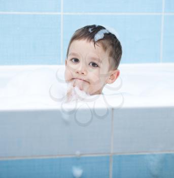 Small child bathes in a bathroom