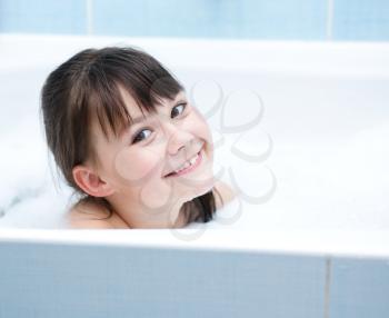 Cute girl bathes in a bathroom