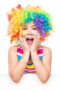 Cute girl in clown wig is holding blank banner, isolated over white