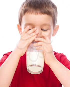 Cute little boy drinks milk using a drinking straw, isolated over white