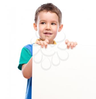 Happy boy is holding blank banner, isolated over white