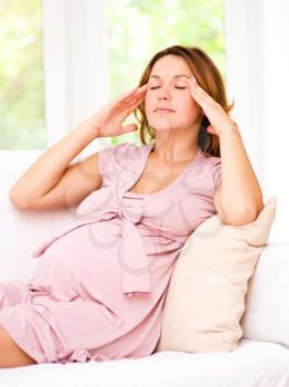 Image of pregnant woman is suffering headache