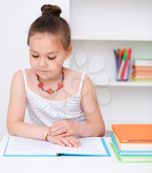 Cute girl is reading book - school, education concept