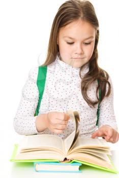 Cute girl is reading book - school, education concept, isolated over white
