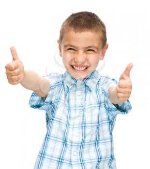 Happy boy is showing thumb up gesture using both hands, isolated over white