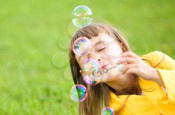 Portrait of cute girl blowing soap bubbles
