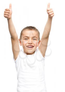 Happy boy is showing thumb up gesture using both hands, isolated over white