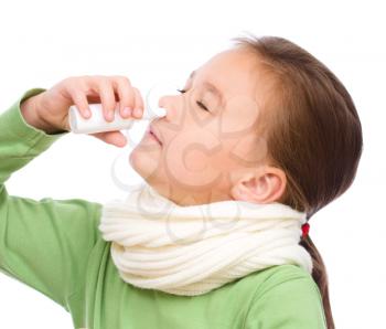 Cute girl spraying her nose with nasal spray, isolated over white