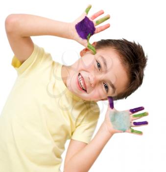 Portrait of a cute boy showing her hands painted in bright colors, isolated over white