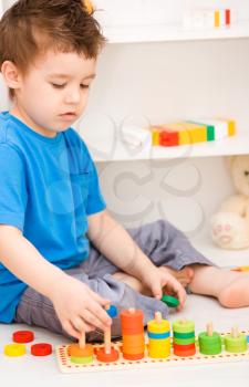 Cute little boy is playing with building blocks