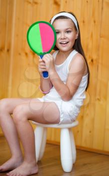 Portrait of a beautiful female athletes with a tennis racket and the tennis ball in his hands, isolated over white