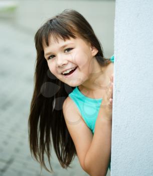 Young cheerful girl is playing outdoors