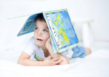 Cute little boy is reading book