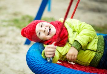 Cute happy girl is playing on playground, outdoor