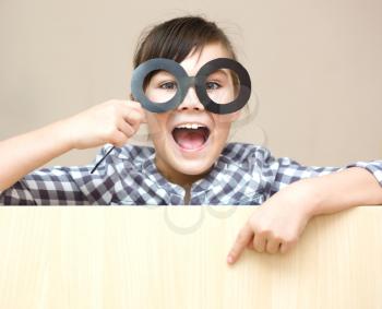Funny girl with fake glasses. Happy child playing in home