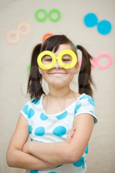 Funny girl with fake glasses. Happy child playing in home