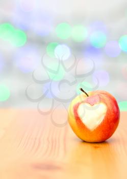 red apple in the form of heart on a wooden background