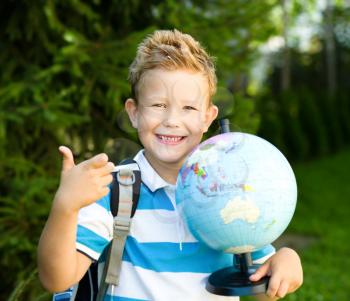 Cute boy is holding globe - education concept