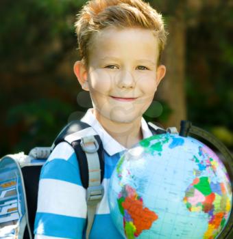 Cute boy is holding globe - education concept
