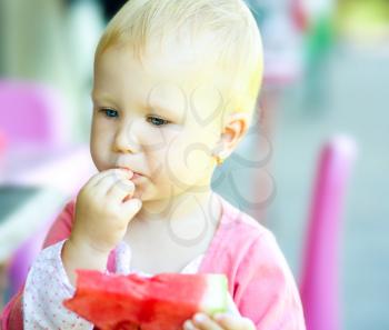 Little cute girl is eating watermelon