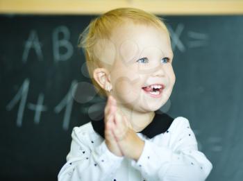 Cute girl is holding blackboard - education concept