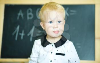 Cute girl is holding blackboard - education concept