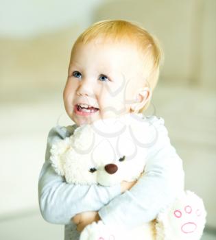 Little cute girl is playing her teddy bear
