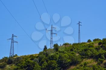 High-voltage tower. Electric powerlines on the blue sky.