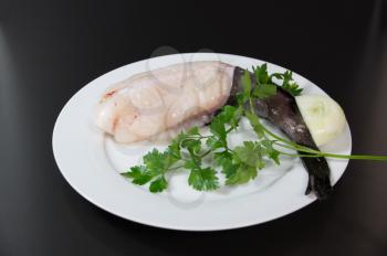 Fresh fish  European monkfish on white plate black background
