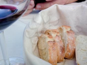 Slices of bread with Golden crust in white basket. Freshly baked and fragrant bread on table in restaurant. Italy.