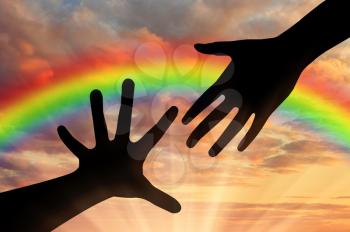 Helping hand concept. Helping Hand of God against the backdrop of a rainbow sky