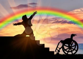 Disability. Happy disabled near the wheelchair is experiencing the joy of watching the sunset and rainbow