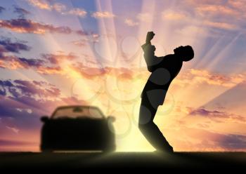 Happiness and success. Happy businessman beside the car on the sunset background